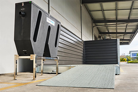 A Cleanawater portable car wash bay outside of a commercial building.